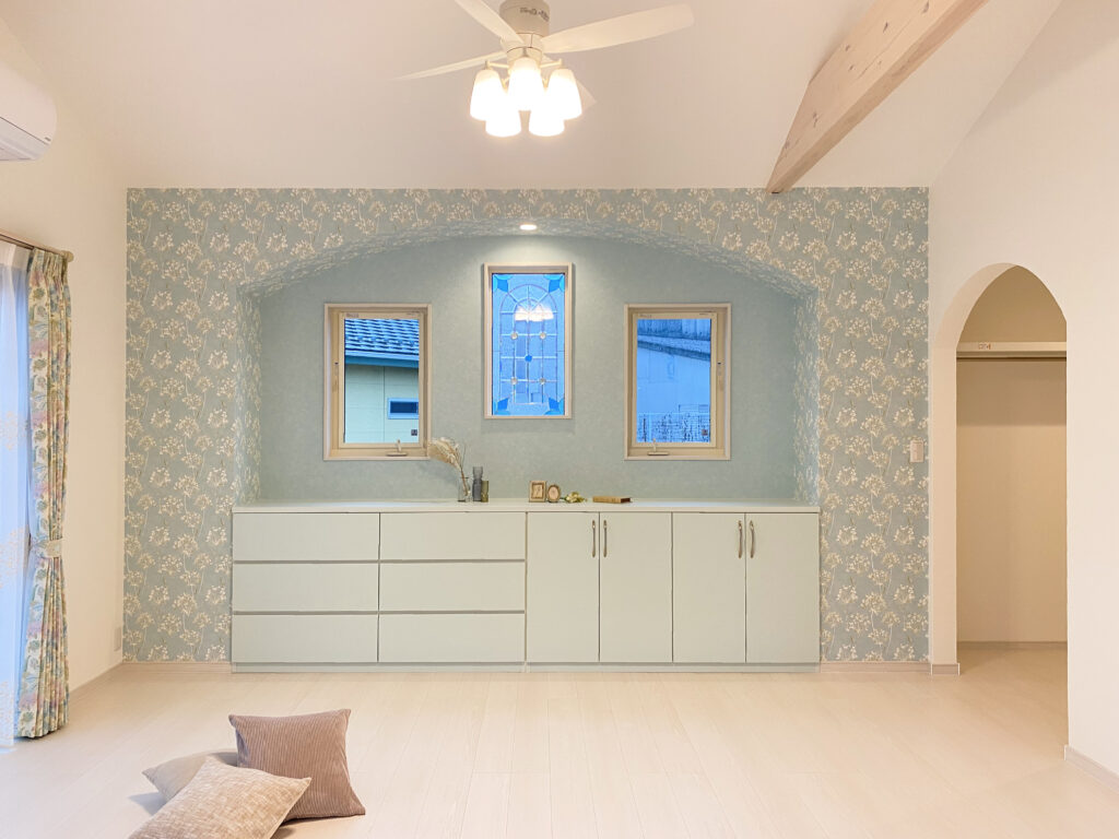 ステンドグラスと淡いブルーの造作収納がある平屋