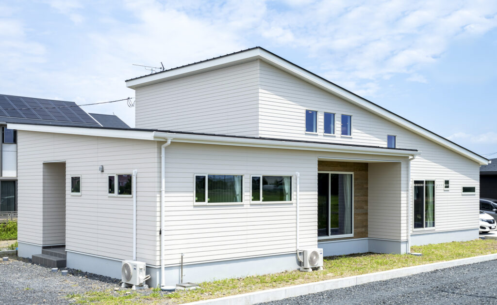 西向きに玄関のあるラップサイディングのおしゃれな平屋注文住宅